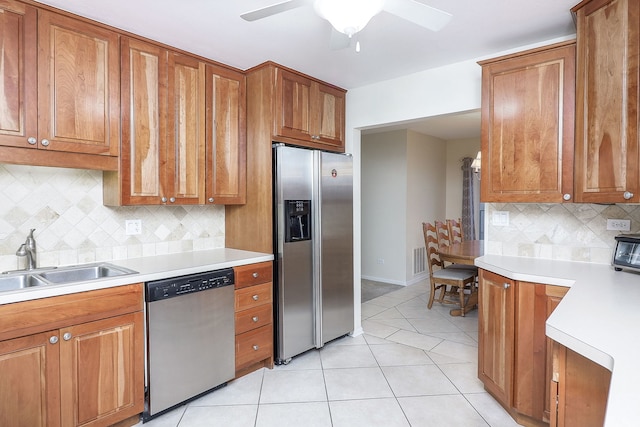 kitchen featuring light tile patterned flooring, appliances with stainless steel finishes, sink, backsplash, and ceiling fan