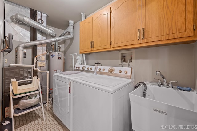 clothes washing area with washer and dryer, sink, water heater, and cabinets