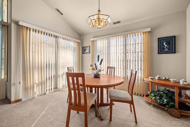 carpeted dining area with lofted ceiling and a notable chandelier