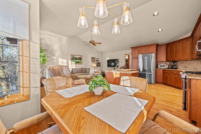 dining room featuring lofted ceiling, light wood-type flooring, and ceiling fan