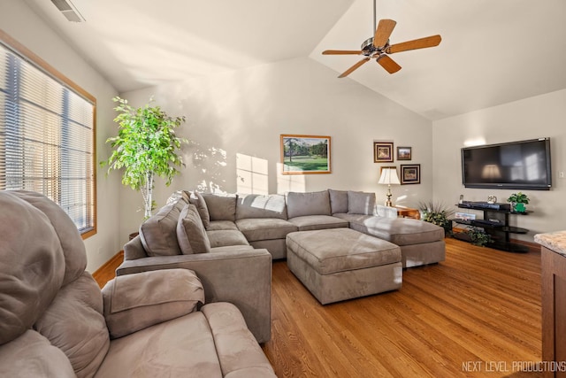 living room with high vaulted ceiling, ceiling fan, and light hardwood / wood-style flooring