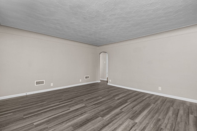 unfurnished room with dark hardwood / wood-style flooring and a textured ceiling