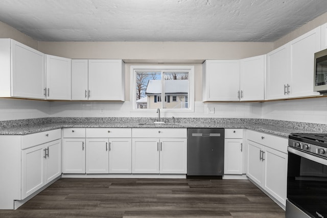 kitchen featuring sink, appliances with stainless steel finishes, white cabinetry, a textured ceiling, and dark hardwood / wood-style flooring