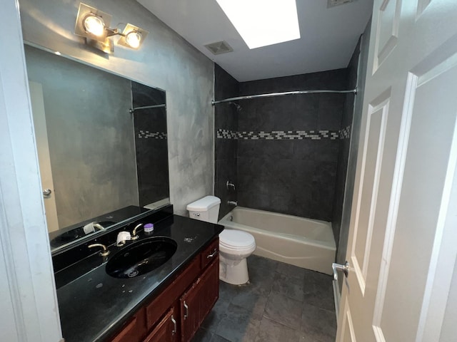 full bathroom with a skylight, tiled shower / bath, vanity, and toilet