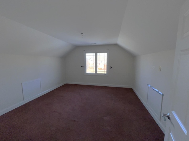 bonus room featuring lofted ceiling and dark carpet