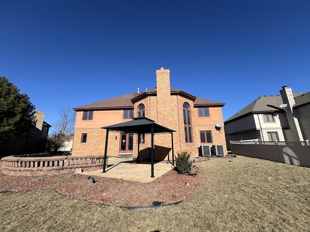 rear view of property with a lawn, central AC, and a patio area