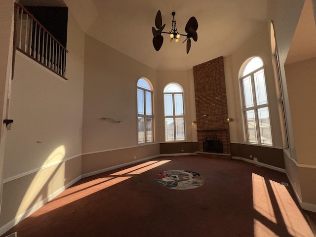 unfurnished living room with a brick fireplace, a healthy amount of sunlight, and carpet flooring