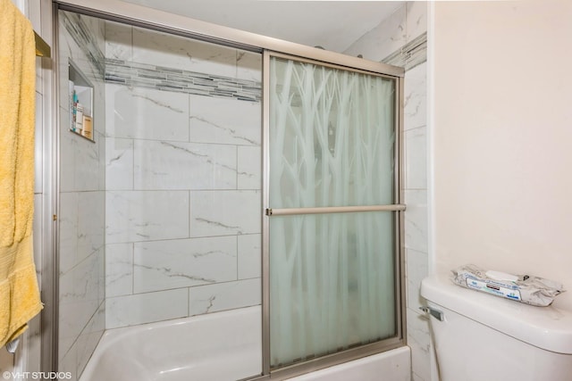 bathroom with combined bath / shower with glass door and toilet