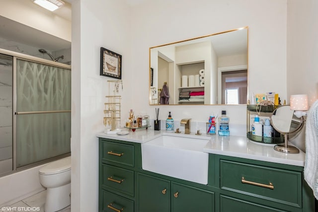 full bathroom featuring tile patterned flooring, vanity, toilet, and bath / shower combo with glass door