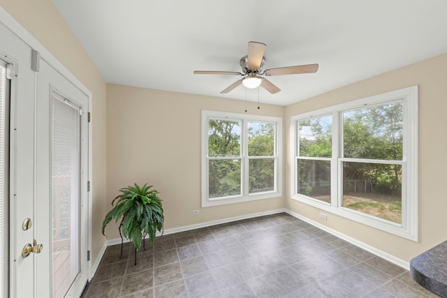 unfurnished sunroom featuring ceiling fan