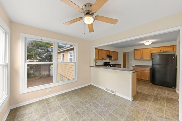 kitchen featuring black fridge, ceiling fan, kitchen peninsula, and electric range