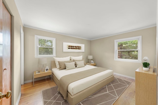 bedroom with ornamental molding and light wood-type flooring