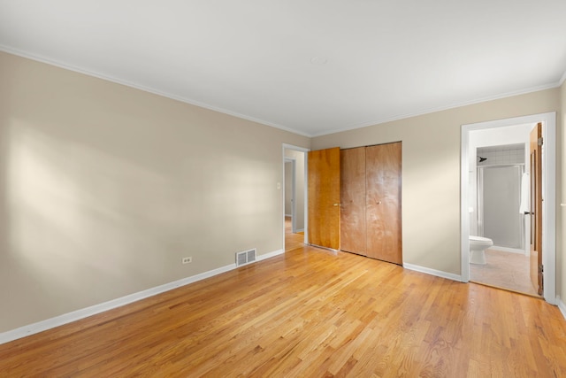 unfurnished bedroom with crown molding, light hardwood / wood-style floors, and ensuite bathroom