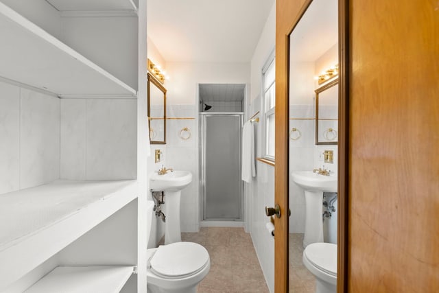 bathroom featuring tile walls, a shower with door, and toilet