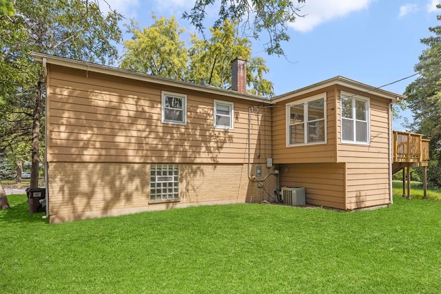 back of house featuring a wooden deck, a yard, and central AC