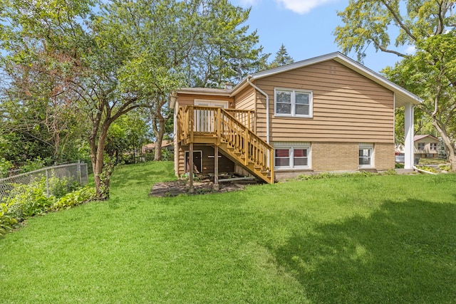 rear view of property with a wooden deck and a lawn