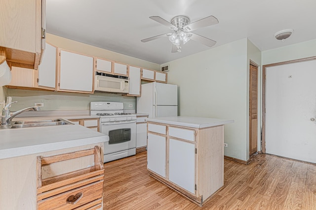 kitchen featuring sink, white appliances, light hardwood / wood-style flooring, and a kitchen island