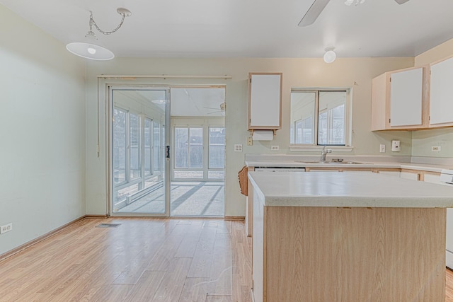 kitchen with a kitchen island, white cabinets, hanging light fixtures, ceiling fan, and light wood-type flooring