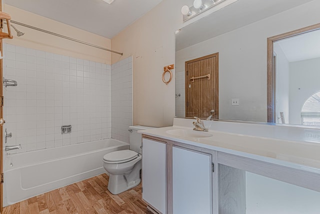 full bathroom featuring tiled shower / bath, wood-type flooring, toilet, and vanity