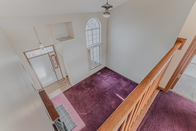 entryway with a high ceiling and carpet flooring