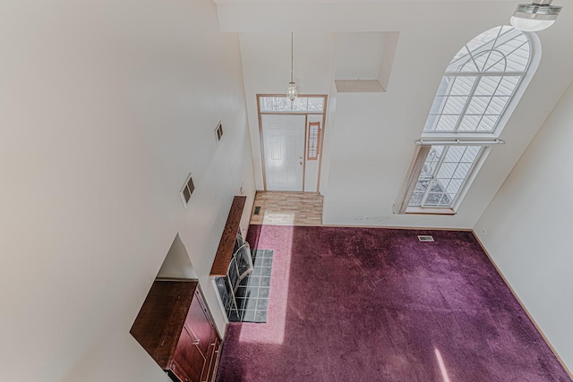 carpeted entrance foyer with a high ceiling