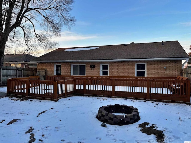 snow covered property with a deck and an outdoor fire pit