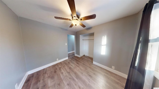 unfurnished bedroom featuring ceiling fan, light hardwood / wood-style floors, and a closet