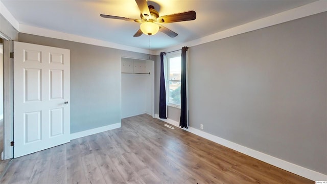 unfurnished bedroom with ceiling fan, light wood-type flooring, and a closet