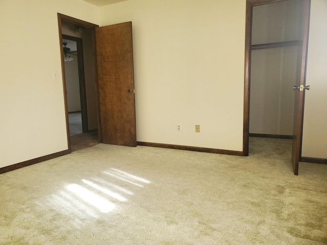 unfurnished bedroom with a walk in closet, light carpet, and a closet