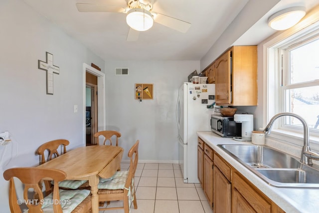 kitchen with ceiling fan, sink, white fridge, and light tile patterned floors