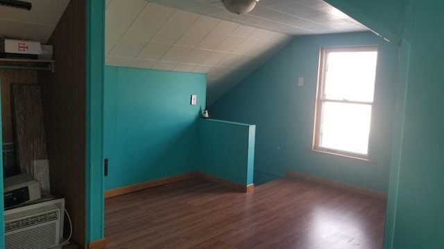 additional living space featuring lofted ceiling, a healthy amount of sunlight, and wood finished floors