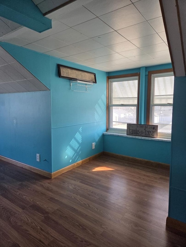 empty room with plenty of natural light, baseboards, and wood finished floors