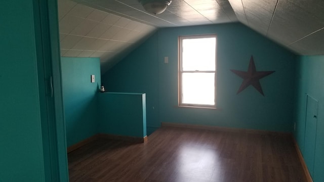 bonus room with vaulted ceiling, wood finished floors, and baseboards