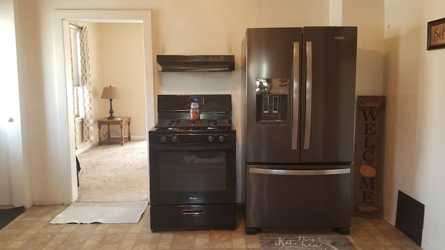 kitchen featuring under cabinet range hood, stainless steel fridge, and black gas range