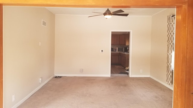 spare room featuring light carpet, baseboards, visible vents, and a ceiling fan