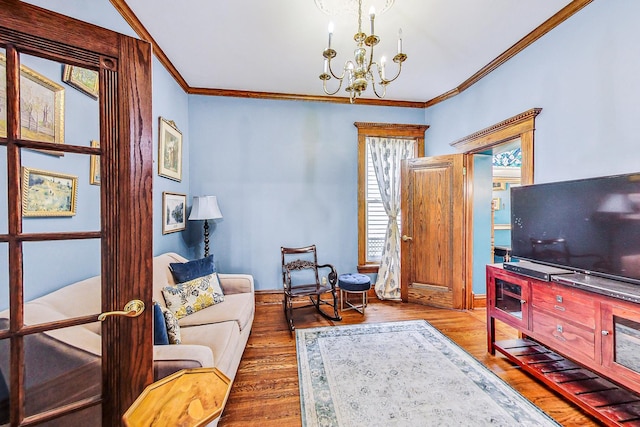 living room featuring ornamental molding, wood finished floors, and a notable chandelier