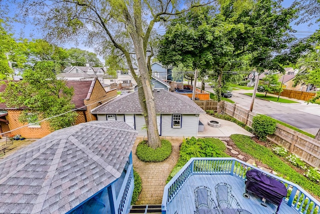 exterior space featuring a shingled roof, a residential view, a fenced backyard, and a patio