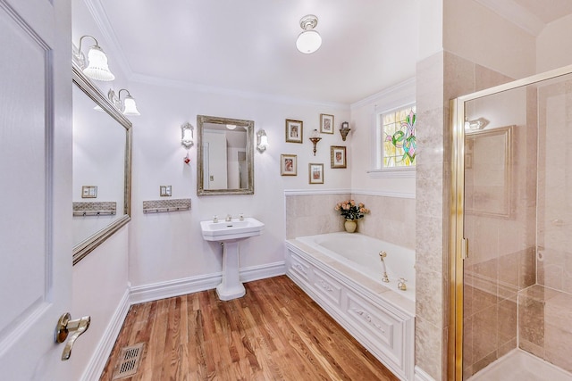 bathroom featuring a shower stall, visible vents, crown molding, and wood finished floors