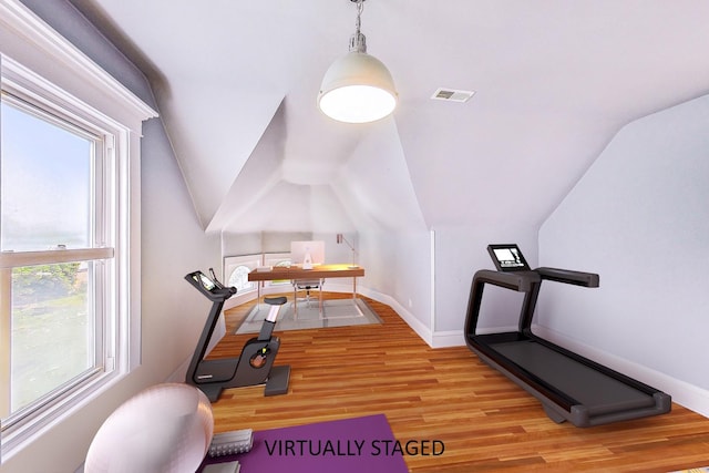 exercise area with lofted ceiling, light wood-style flooring, visible vents, and baseboards