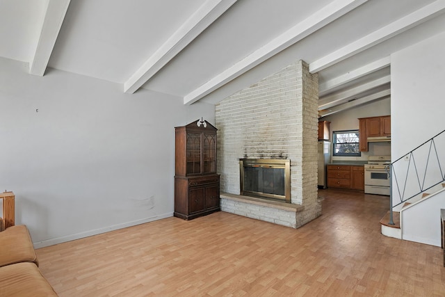 unfurnished living room with light wood-type flooring, a brick fireplace, and vaulted ceiling with beams