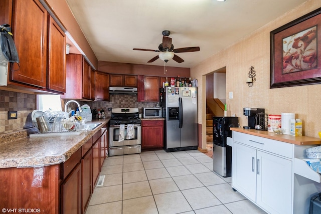 kitchen featuring light tile patterned flooring, sink, decorative backsplash, ceiling fan, and stainless steel appliances