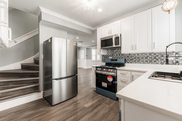 kitchen featuring sink, dark wood-type flooring, stainless steel appliances, ornamental molding, and white cabinets