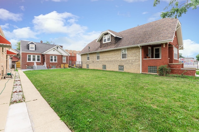 rear view of house featuring a yard