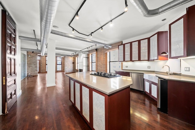 kitchen with decorative light fixtures, a kitchen island, appliances with stainless steel finishes, and brick wall