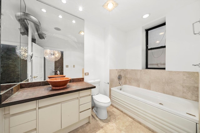 bathroom with vanity, toilet, and a tub