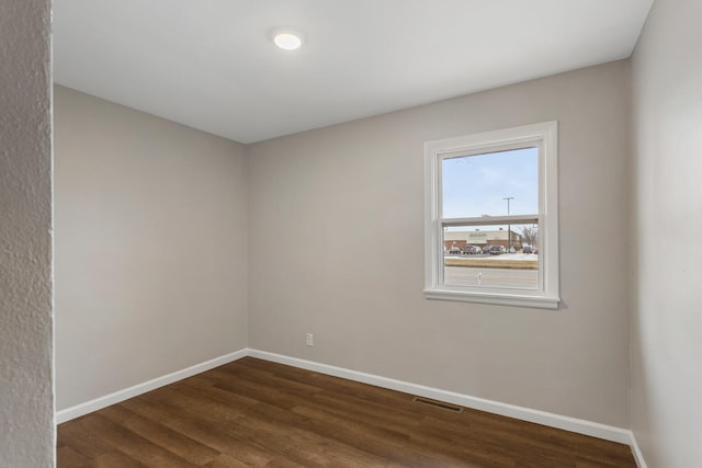 unfurnished room featuring dark wood-type flooring