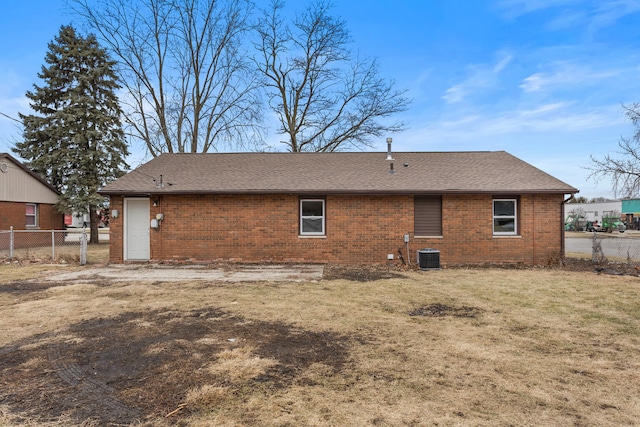 rear view of property with cooling unit and a lawn