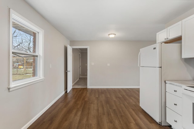 kitchen featuring white cabinetry, white fridge, and dark wood-type flooring