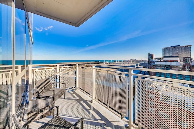 balcony featuring a view of the beach and a water view