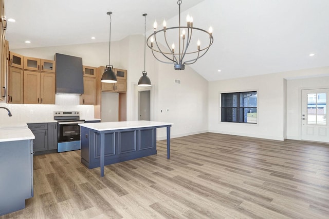 kitchen with stainless steel electric range oven, a center island, pendant lighting, and wall chimney exhaust hood